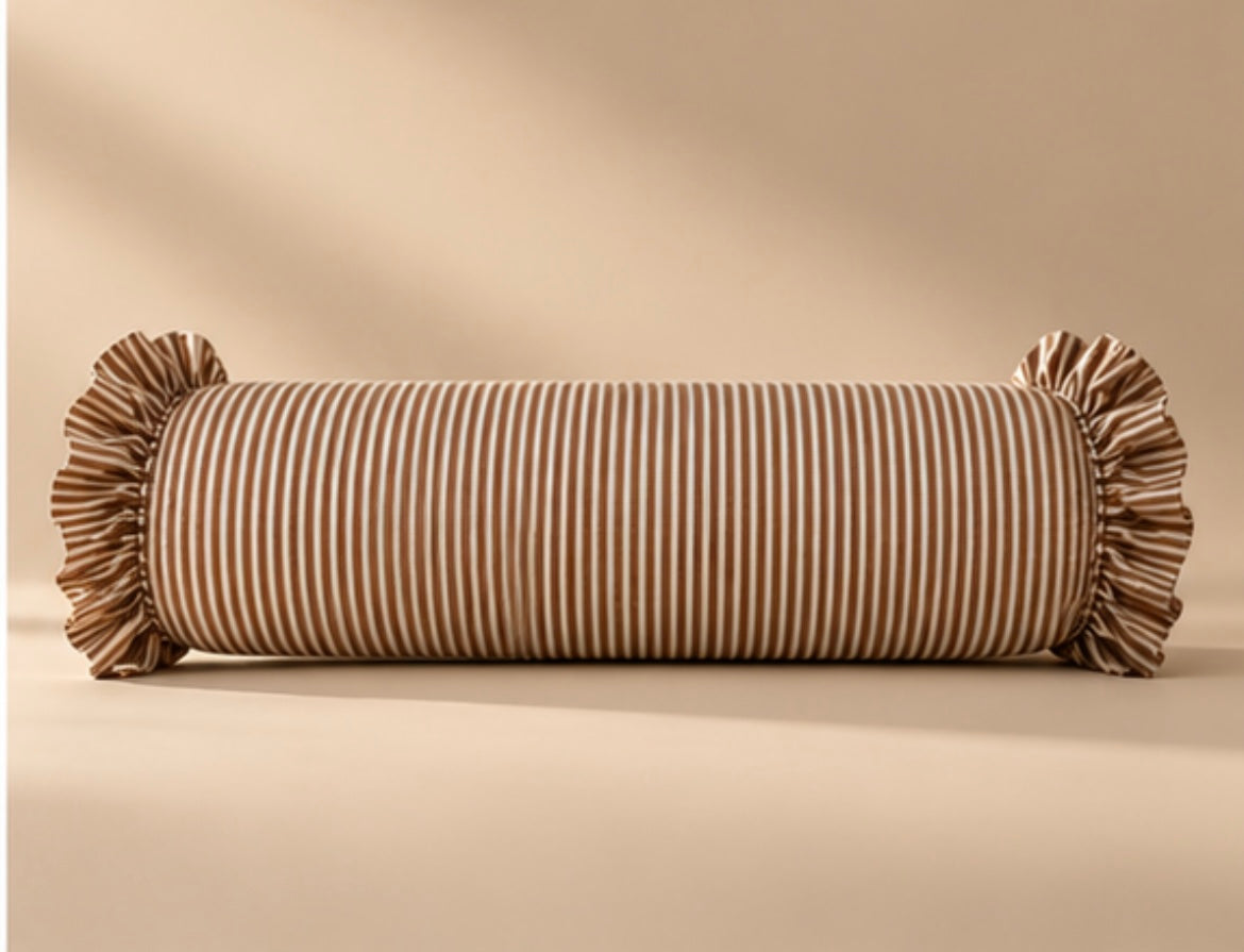 Pillow Classique, traversin rayé rose à volants posé sur un lit